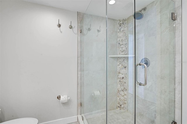 full bath featuring a shower stall, toilet, and baseboards