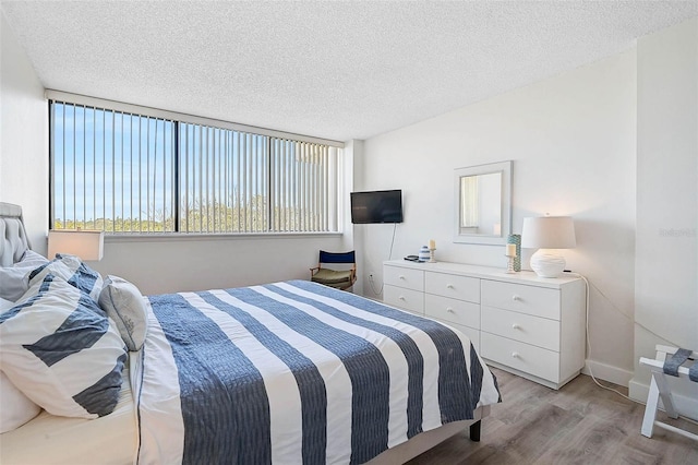 bedroom with light wood-style flooring and a textured ceiling