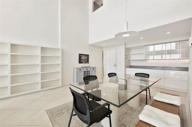 dining space with light tile patterned floors, a high ceiling, and recessed lighting