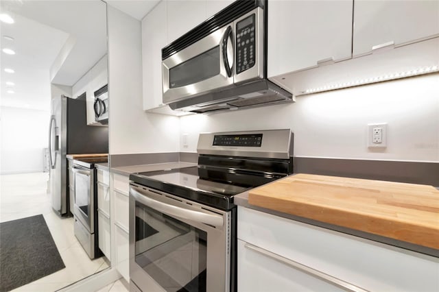 kitchen with light tile patterned floors, white cabinetry, appliances with stainless steel finishes, and recessed lighting