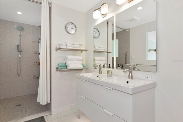 bathroom featuring a sink, visible vents, tiled shower, tile patterned floors, and double vanity