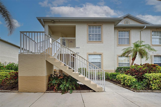 view of front of house featuring stairs and stucco siding