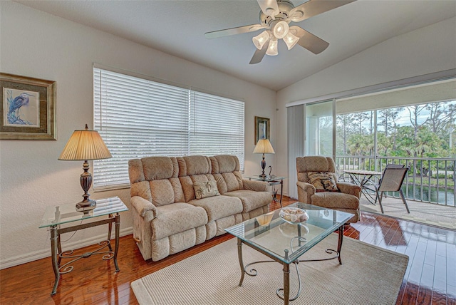 living area featuring ceiling fan, vaulted ceiling, baseboards, and wood finished floors