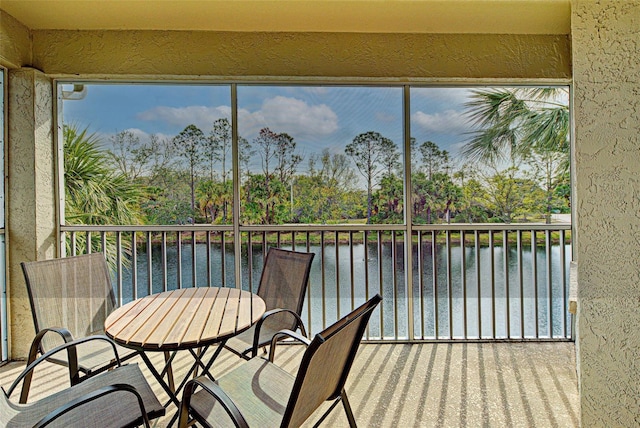 sunroom featuring a water view