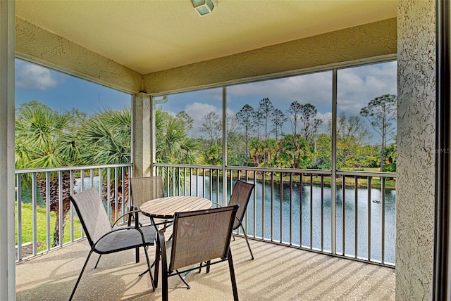 sunroom featuring a water view