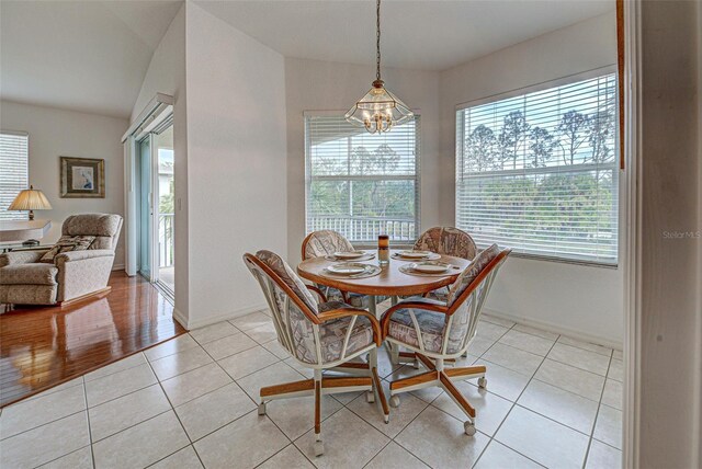 dining area with light tile patterned floors, baseboards, and a notable chandelier