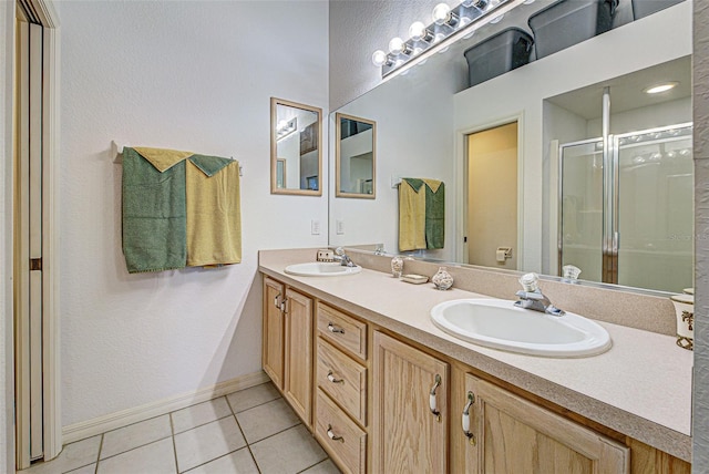 full bathroom with double vanity, a stall shower, tile patterned flooring, and a sink