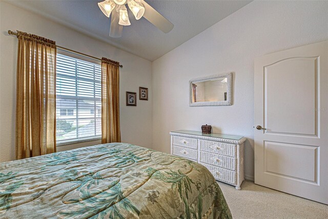 bedroom with light carpet, lofted ceiling, and a ceiling fan