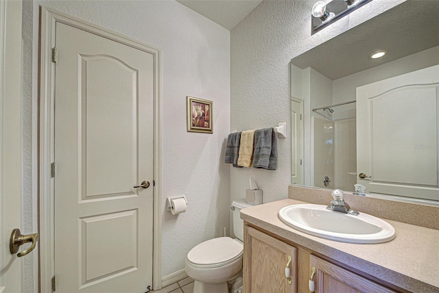 bathroom featuring a textured wall, toilet, vanity, tile patterned floors, and walk in shower