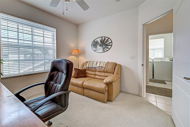 carpeted home office featuring washing machine and dryer, tile patterned flooring, and ceiling fan