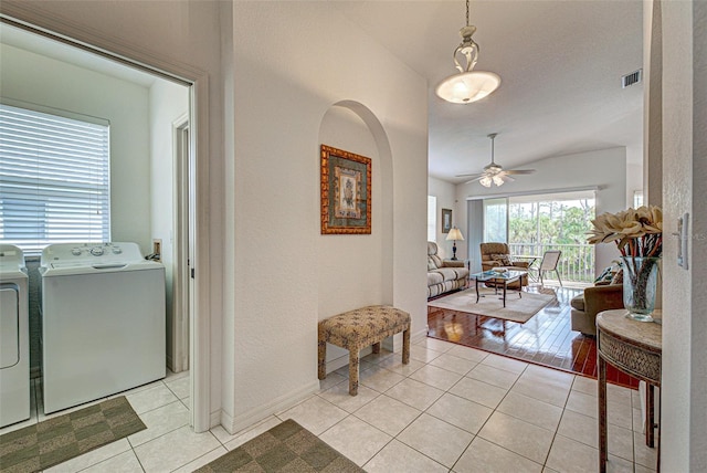 interior space featuring washer and dryer, visible vents, lofted ceiling, and light tile patterned floors