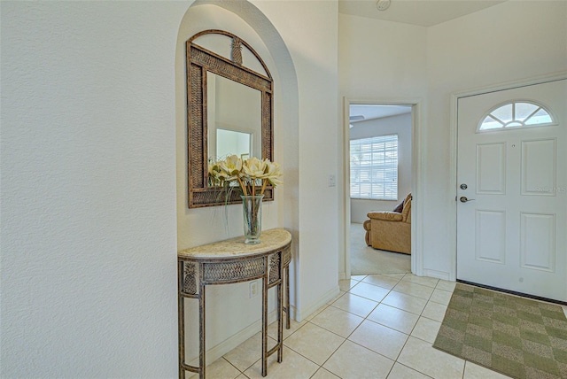 foyer entrance featuring baseboards and light tile patterned floors