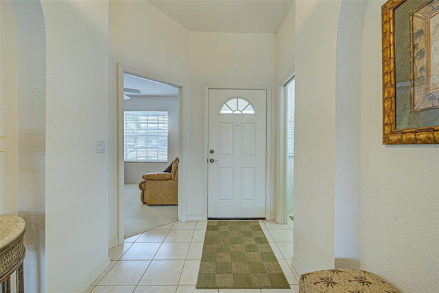 foyer entrance with light tile patterned flooring and baseboards