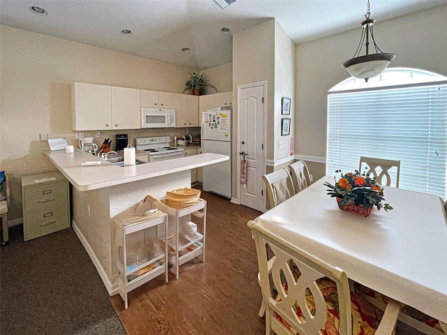 kitchen featuring dark wood-style flooring, light countertops, white cabinetry, white appliances, and a peninsula