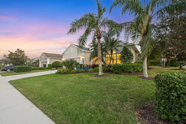 obstructed view of property featuring a front yard, driveway, an attached garage, and stucco siding