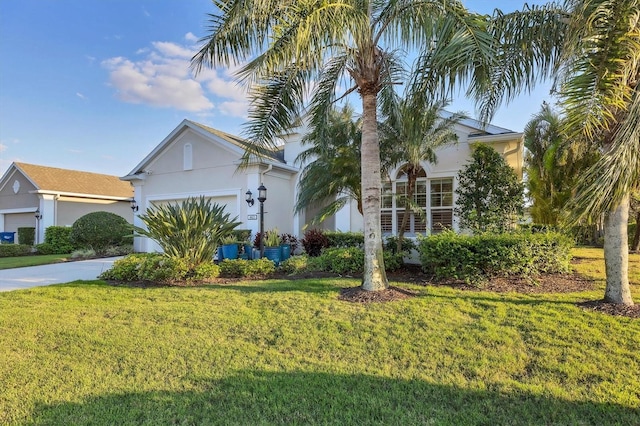 view of front facade with driveway, a front yard, an attached garage, and stucco siding