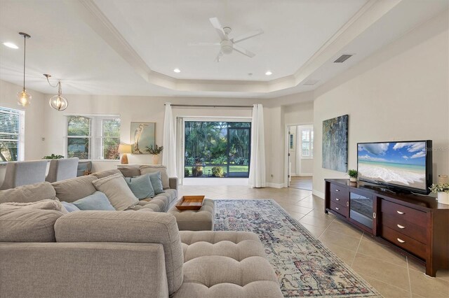 living room featuring light tile patterned floors, a tray ceiling, visible vents, and recessed lighting