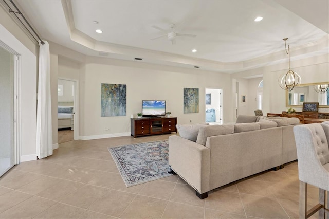 living room with light tile patterned floors, a raised ceiling, and recessed lighting