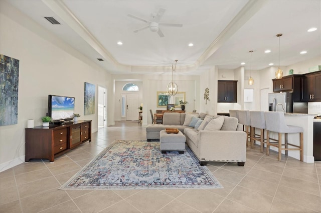 living room with recessed lighting, visible vents, a raised ceiling, and light tile patterned flooring