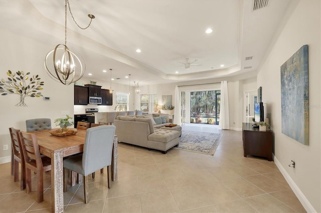 dining room with a tray ceiling, visible vents, baseboards, and light tile patterned flooring