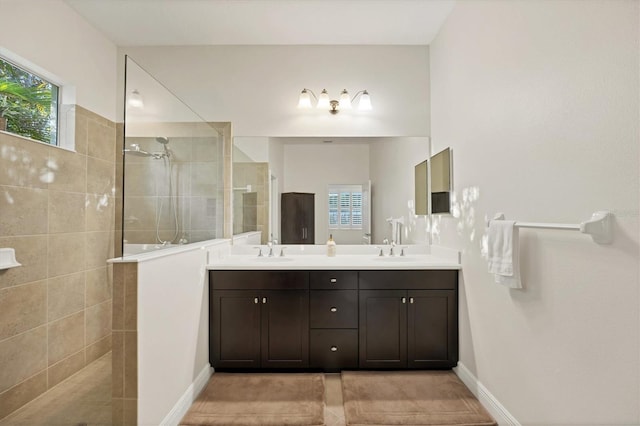 full bath featuring double vanity, walk in shower, and a sink