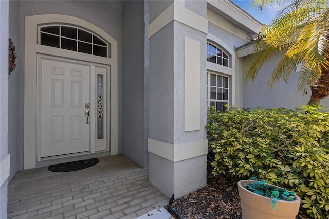 doorway to property featuring stucco siding