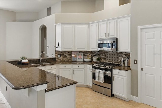 8420 Sailing Loop, Lakewood Ranch, FL 34202 - kitchen featuring stainless steel appliances, a sink, tasteful backsplash, a peninsula, and white cabinetry
