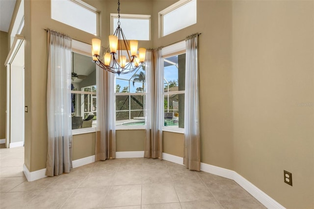 8420 Sailing Loop, Lakewood Ranch, FL 34202 - unfurnished dining area featuring a chandelier, light tile patterned flooring, baseboards, and a high ceiling