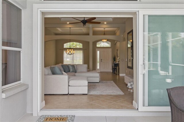 8420 Sailing Loop, Lakewood Ranch, FL 34202 - tiled living area with ceiling fan, a chandelier, coffered ceiling, and arched walkways
