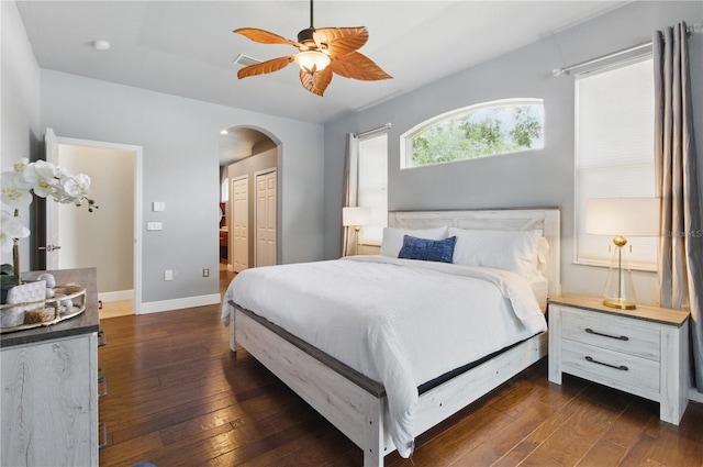8420 Sailing Loop, Lakewood Ranch, FL 34202 - bedroom with arched walkways, dark wood-style flooring, baseboards, a closet, and a ceiling fan