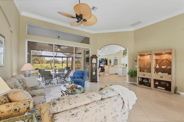 tiled living area with arched walkways, ceiling fan, a sunroom, visible vents, and crown molding