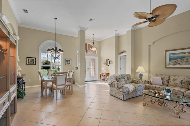 living room with light tile patterned floors, visible vents, baseboards, a towering ceiling, and crown molding