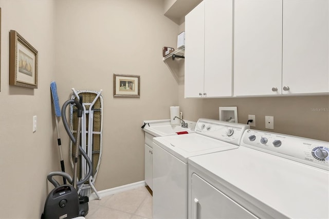 washroom with cabinet space, baseboards, a sink, and independent washer and dryer