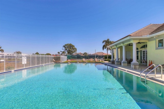 pool with a patio area, fence, and ceiling fan