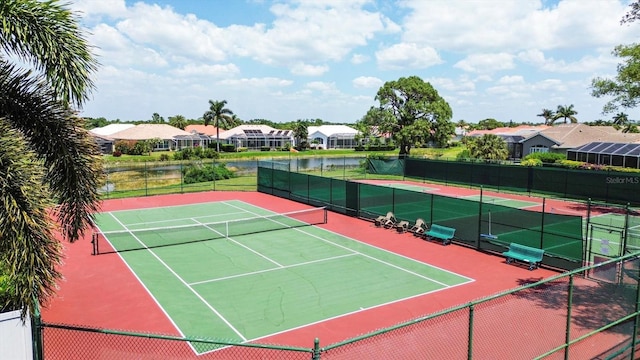 view of tennis court with a residential view and fence