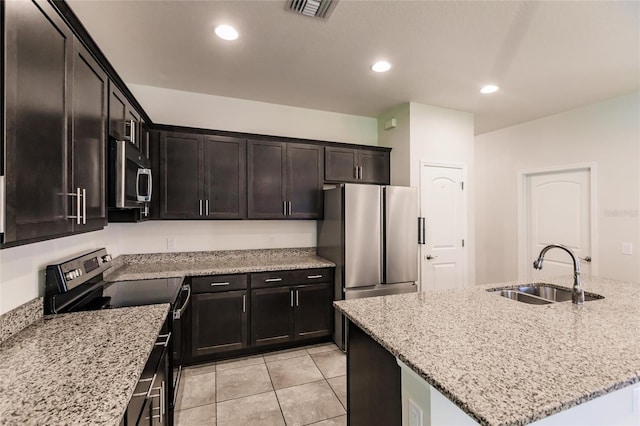 kitchen with light stone countertops, visible vents, stainless steel appliances, and a sink