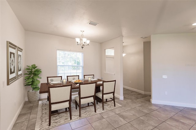 dining area featuring light tile patterned floors, baseboards, visible vents, and a chandelier