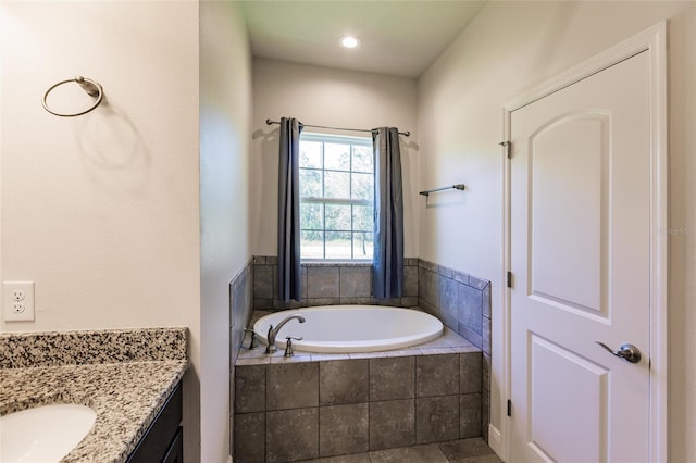 full bathroom with vanity and a bath