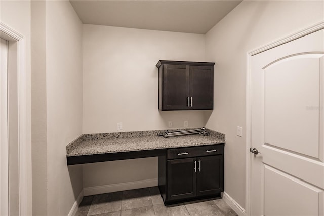 interior space featuring built in study area and baseboards