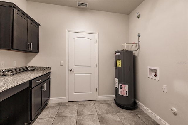 interior space featuring cabinet space, baseboards, visible vents, electric water heater, and hookup for a washing machine