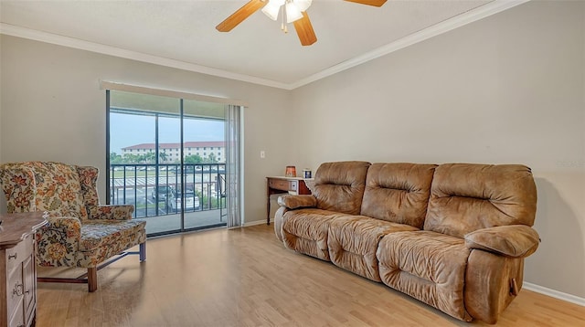 living room with a ceiling fan, crown molding, light wood-style flooring, and baseboards