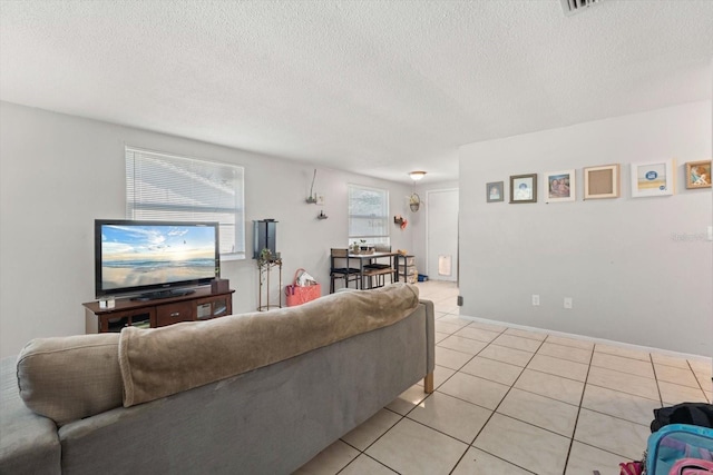 living area featuring a textured ceiling and light tile patterned floors