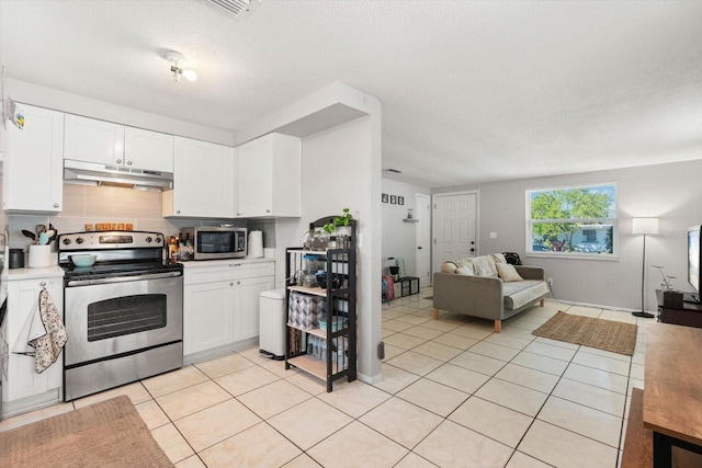 kitchen with under cabinet range hood, light tile patterned flooring, stainless steel appliances, and open floor plan