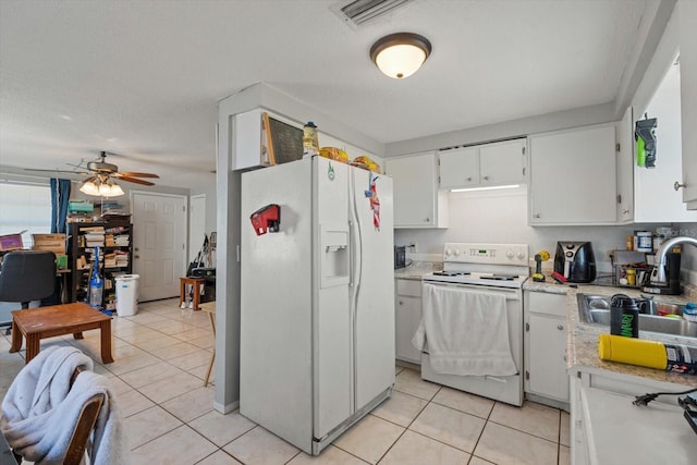 kitchen with light tile patterned floors, light countertops, white appliances, and a sink