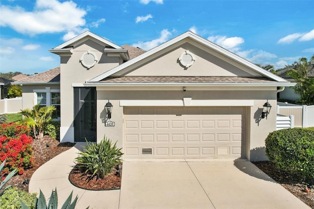 view of front of home with driveway, a garage, a shingled roof, fence, and stucco siding