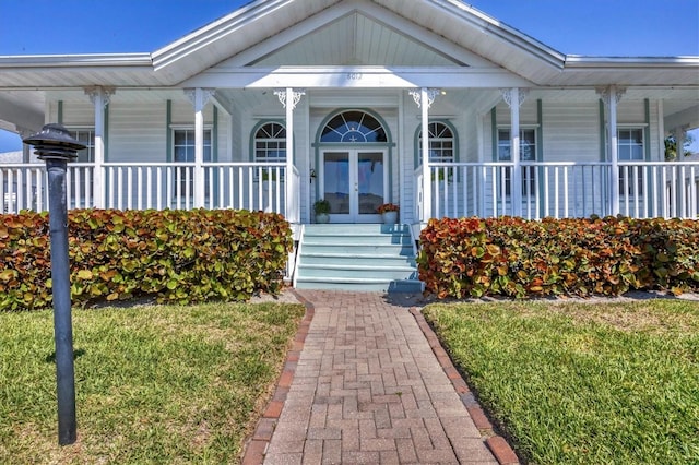 property entrance with covered porch and french doors