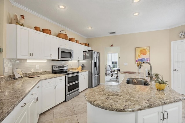 kitchen with decorative backsplash, white cabinetry, stainless steel appliances, and a sink