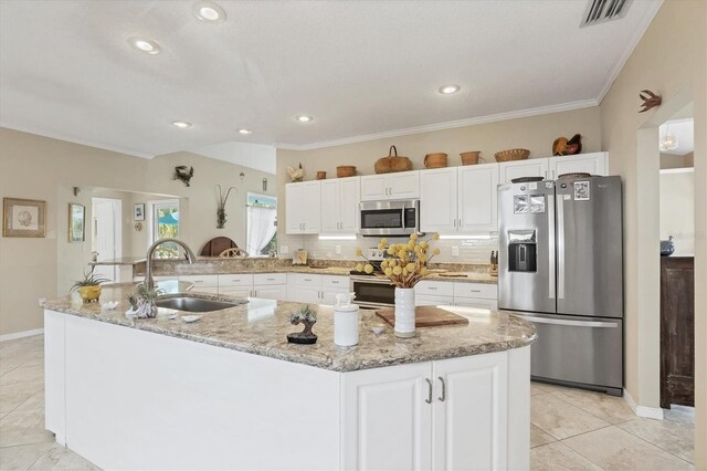 kitchen with a sink, visible vents, white cabinetry, appliances with stainless steel finishes, and decorative backsplash