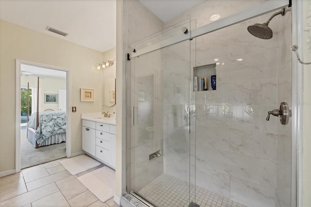 bathroom featuring a marble finish shower, visible vents, connected bathroom, vanity, and tile patterned flooring