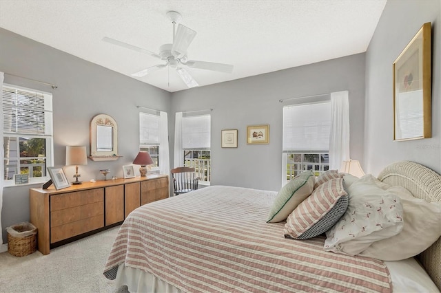 bedroom with a ceiling fan, light colored carpet, and multiple windows